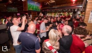 Fans at the living room enjoying a game of football Photo Living room Facebook